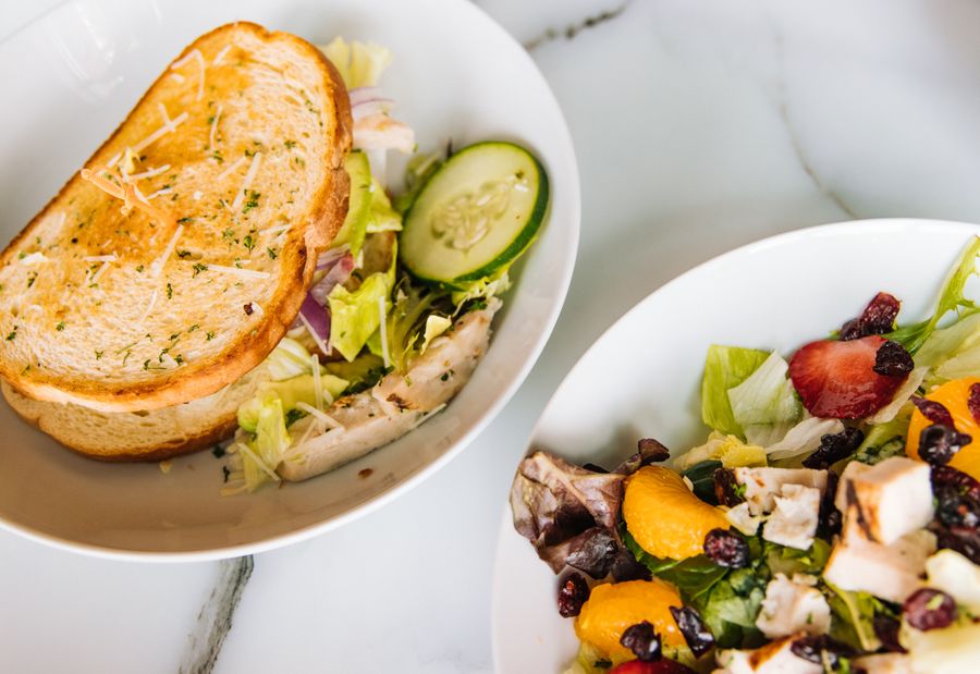 A perfectly ordinary lunch on a desk — a sandwich, pasta and a coffee